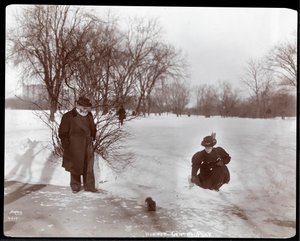 Zicht op een vrouw die een eekhoorn voedt terwijl een man toekijkt in de sneeuw in Central Park, New York, 1898